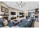 Open-concept living room featuring a fireplace, ceiling fan, and seamless flow into the kitchen area at 4292 Helena Cove Ct, Las Vegas, NV 89129