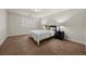 A sunlit bedroom featuring carpet, neutral walls, a queen-size bed, dark side tables with lamps and plantation shutters at 4439 Melrose Abbey Pl, Las Vegas, NV 89141