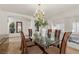 Elegant dining room with glass-top table, modern chairs, and chandelier lighting fixture at 4439 Melrose Abbey Pl, Las Vegas, NV 89141