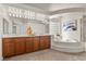 Luxurious main bathroom features a step-up tub, vanity, and natural light at 4439 Melrose Abbey Pl, Las Vegas, NV 89141