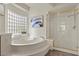 Luxurious bathroom featuring a soaking tub, a separate shower, and natural light at 4439 Melrose Abbey Pl, Las Vegas, NV 89141