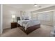 Bright main bedroom featuring a large bed, carpeted floors, and windows with stylish shutters at 4439 Melrose Abbey Pl, Las Vegas, NV 89141