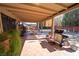 Outdoor back patio, featuring tile, covered seating area with grill, and a well manicured backyard at 5873 Corazon Dr, Las Vegas, NV 89103