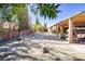 Large backyard featuring desert landscaping, tall trees, privacy fence, patio and playhouse at 5873 Corazon Dr, Las Vegas, NV 89103