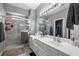 Modern bathroom featuring a glass-enclosed shower, a large mirror, and a walk-in closet at 5940 Palmilla St # 9, North Las Vegas, NV 89031