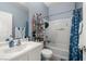 Bright bathroom featuring a shower-tub combo with blue floral curtain, and white vanity at 5940 Palmilla St # 9, North Las Vegas, NV 89031