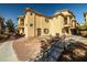 Rear exterior of townhome with walkways and stairs featuring stucco facade and brown trim at 5940 Palmilla St # 9, North Las Vegas, NV 89031