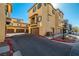 View of the building exterior, garages, and parking spaces on a sunny day at 5940 Palmilla St # 9, North Las Vegas, NV 89031