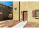 Townhome front entrance showing walkway leading to a brown front door with sidelight at 5940 Palmilla St # 9, North Las Vegas, NV 89031