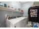 Functional laundry room with a modern white washer and dryer and shelf storage at 5940 Palmilla St # 9, North Las Vegas, NV 89031