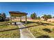Shaded picnic area on a grassy lawn under a covered structure, featuring a sidewalk at 5940 Palmilla St # 9, North Las Vegas, NV 89031