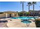 Community pool area with palm trees, lounge area, and nearby buildings at 5940 Palmilla St # 9, North Las Vegas, NV 89031