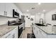 Open kitchen with island, stainless steel appliances, and access to backyard at 6867 Evening Orchid St, North Las Vegas, NV 89086