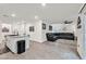 Living area with L-shaped sectional, access to patio, and open kitchen view at 6867 Evening Orchid St, North Las Vegas, NV 89086