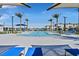 Community pool with lounge chairs and umbrellas at 6867 Evening Orchid St, North Las Vegas, NV 89086