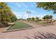 Active community bocce ball court with mature shade trees and bright blue sky with a few scattered clouds at 723 Orange Plume Walk # 0, Henderson, NV 89011