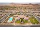 Aerial view of a community clubhouse, pool, green spaces, and residential homes with mountain views in the background at 723 Orange Plume Walk # 0, Henderson, NV 89011