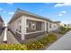 Charming home exterior with a covered porch, stone accents, well-maintained landscaping, and yellow flowers in the front yard at 723 Orange Plume Walk # 0, Henderson, NV 89011