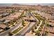 Aerial view of the community gate with desert landscaping, neighborhood homes, and mountain views at 723 Orange Plume Walk # 0, Henderson, NV 89011