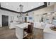 Modern community kitchen with sleek white cabinetry, a large island with bar stools, and state-of-the-art appliances at 723 Orange Plume Walk # 0, Henderson, NV 89011