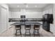Modern kitchen with black appliances, granite countertops, and a central island with seating at 723 Orange Plume Walk # 0, Henderson, NV 89011