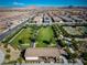 Scenic aerial view of a fenced park with trees, green grass, benches, and a covered picnic pavilion at 723 Orange Plume Walk # 0, Henderson, NV 89011