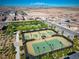 Aerial view of a community tennis court featuring lighting for nighttime play at 723 Orange Plume Walk # 0, Henderson, NV 89011