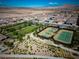 Aerial view of community tennis courts and park featuring professional lighting and fencing at 723 Orange Plume Walk # 0, Henderson, NV 89011