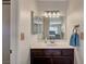 Bathroom featuring wood-look cabinetry and a large mirror at 7559 Silver Leaf Way, Las Vegas, NV 89147