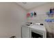 Bright laundry room with washer, dryer, and shelving at 7675 W Mistral Ave, Las Vegas, NV 89113