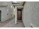 Side entrance with dark brown door and stone pathway at 7675 W Mistral Ave, Las Vegas, NV 89113