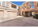 Spacious driveway leading to a two-car garage, with a covered entryway to the charming townhome at 830 Cozette Ct # 102, Las Vegas, NV 89144