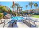 Community hot tub with a rock waterfall feature and poolside lounge chairs, perfect for relaxation at 830 Cozette Ct # 102, Las Vegas, NV 89144