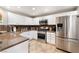 Spacious kitchen featuring white cabinets, stainless steel appliances, and granite countertops at 830 Cozette Ct # 102, Las Vegas, NV 89144