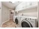 Functional laundry room with a washer, dryer, sink, and storage cabinets at 830 Cozette Ct # 102, Las Vegas, NV 89144