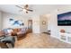 Cozy living room featuring tile flooring, ceiling fan, a leather sofa, and neutral decor at 830 Cozette Ct # 102, Las Vegas, NV 89144