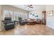 Relaxing living room features a ceiling fan, tile flooring, and a stylish brown leather sofa at 830 Cozette Ct # 102, Las Vegas, NV 89144