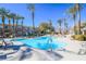 Large swimming pool surrounded by lush landscaping and tall palm trees, creating a tropical oasis at 830 Cozette Ct # 102, Las Vegas, NV 89144
