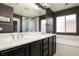 Bathroom with a black vanity and a white double sink, next to a tub and shower combo at 8651 Moreno Mountain Ave, Las Vegas, NV 89178