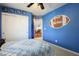 Bedroom with a blue wall and a closet with a ceiling fan above the bed covered with a comforter at 8651 Moreno Mountain Ave, Las Vegas, NV 89178