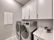 Laundry room with white cabinets, quartz countertop, and modern appliances at 89 Mirage View Dr, Henderson, NV 89011