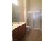 Bathroom with shower, toilet, double vanity, and wood cabinets at 8985 S Durango Dr # 2094, Las Vegas, NV 89113
