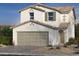 Two-story house with beige exterior, taupe garage door, and landscaping at 9150 Benton Woods St, Las Vegas, NV 89113
