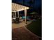 Stunning night view of the backyard with a lighted patio, pool, and manicured lawn at 10654 Sidlaw Hills Ct, Las Vegas, NV 89141