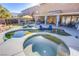 Expansive backyard with a pool, spa, covered patio, and lush artificial grass, great for outdoor living at 10654 Sidlaw Hills Ct, Las Vegas, NV 89141