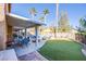 Spacious backyard featuring a covered patio, artificial grass, pool and spa, perfect for outdoor entertaining at 10654 Sidlaw Hills Ct, Las Vegas, NV 89141