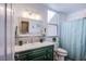 Bathroom with a stylish mirror, green vanity, and shower with a teal curtain at 10654 Sidlaw Hills Ct, Las Vegas, NV 89141
