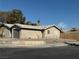 Tan single story house with a grey garage door and wooden fence at 11 Page St, Las Vegas, NV 89110