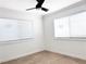 Well-lit bedroom featuring two windows and ceiling fan at 1470 Sutton Dr, Pahrump, NV 89048
