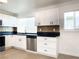 Modern kitchen with white shaker cabinets, dark countertops, and tile backsplash at 1470 Sutton Dr, Pahrump, NV 89048